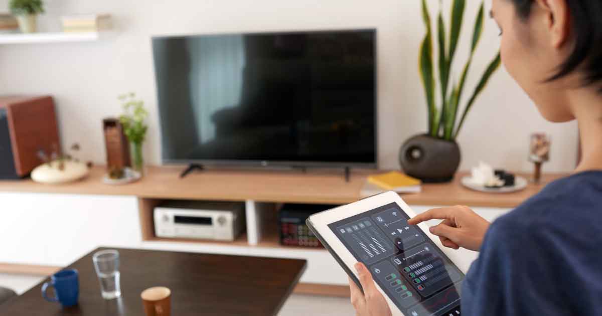 Woman adjusting smart sound system in her living room